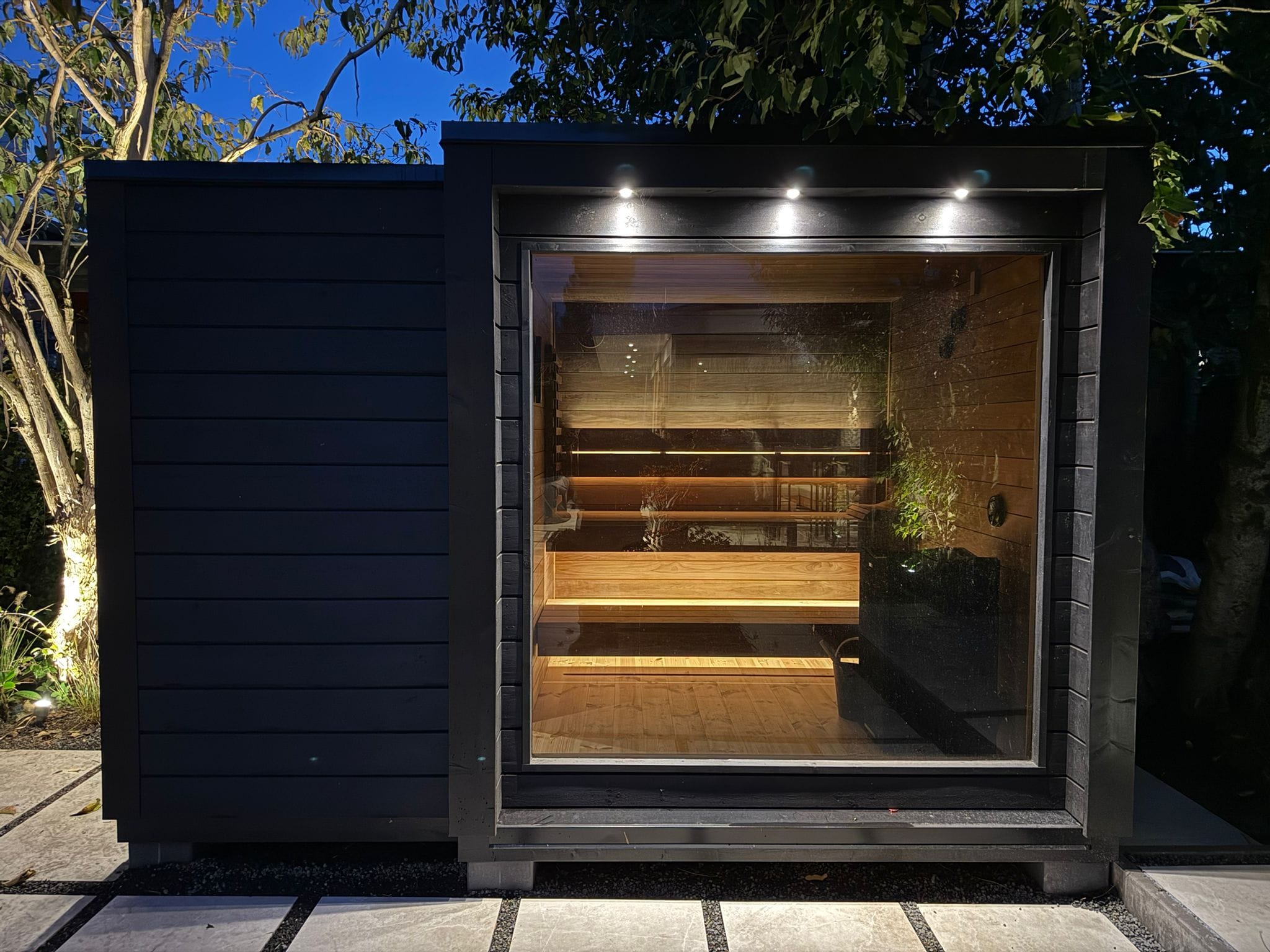 Mökki buitensauna geplaatst in een moderne tuin, project door Altena Zwembaden.