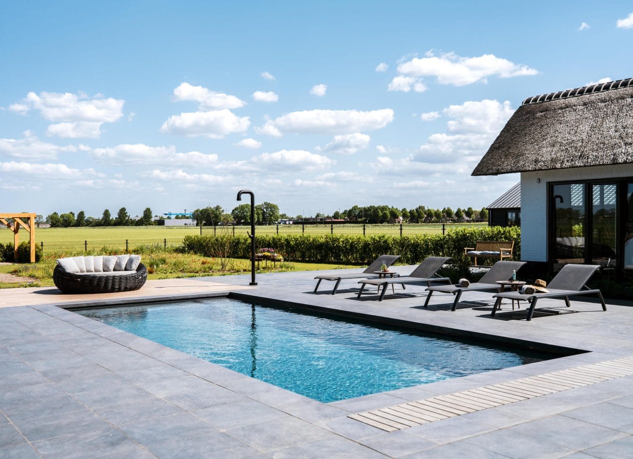 Afgewerkt LPW zwembad in de zomer met kristalhelder water en luxe afwerking in een zonnige tuin.